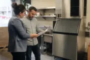 Supermarket employee using flake ice at a fresh food display