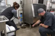 Facilities manager checking commercial ice machine water and drain requirements